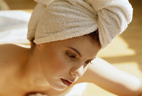 Женщина с обернутыми полотенцем волосами